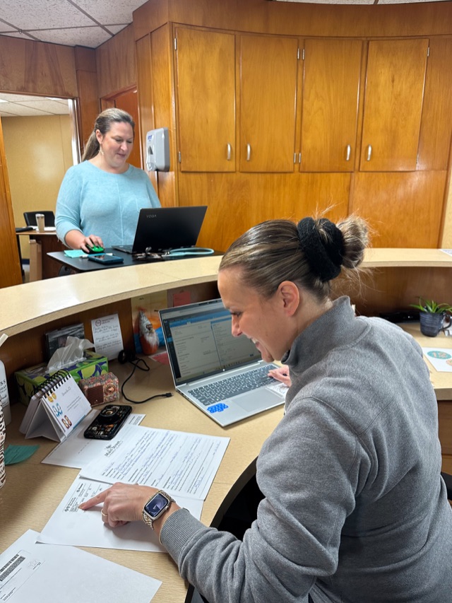 Clinic staff at the front desk welcoming a patient